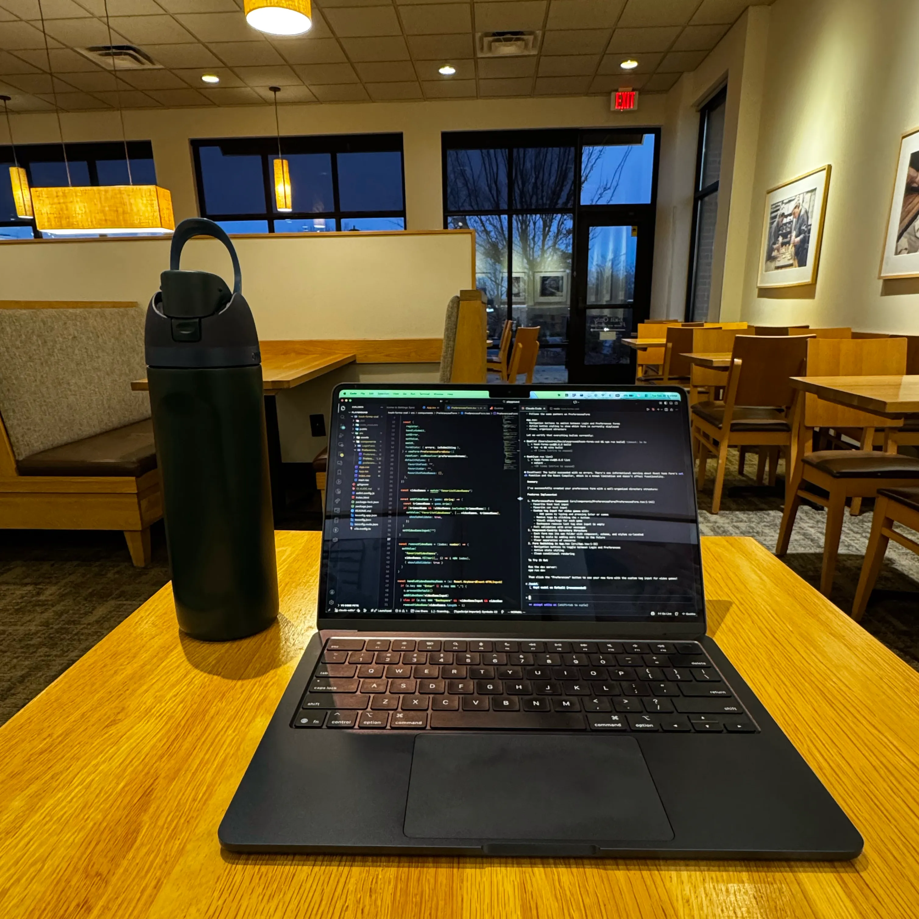 A laptop open to a code editor on a café table.